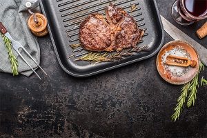 Grilled steak on grill pan with rosemary and spices